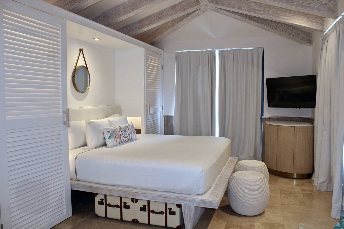 Une chambre à coucher avec un lit, une télévision et une armoire en bois.