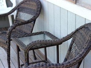 Wicker chairs with glass tops on a wooden deck. - Sandbox 30A - 30A Beach getaway (Santa Rosa Beach)