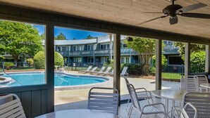 A covered outdoor area with a pool, lounge chairs, and tables. - Beach Retreat 30A Seagrove (Santa Rosa Beach)