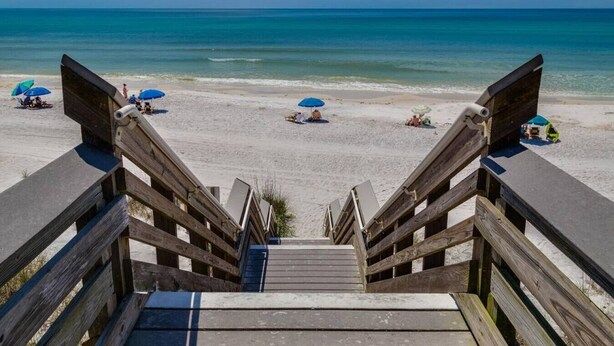 A wooden staircase leading to a beach with umbrellas and sun loungers. - Beach Retreat 30A Seagrove (Santa Rosa Beach)