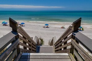A wooden staircase leading to a beach with umbrellas and sun loungers. - Beach Retreat 30A Seagrove (Santa Rosa Beach)