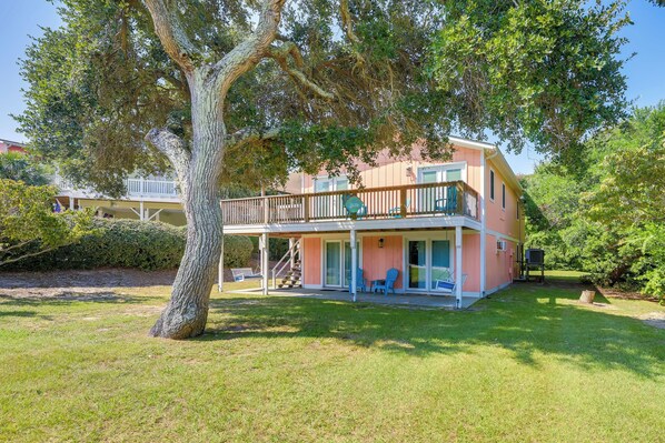 A two-story house with a balcony, surrounded by a well-maintained lawn and trees. - Emerald Isle Vacation Rental, Walk to Beach! (Emerald Isle)