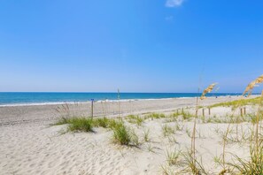 A sandy beach with a clear blue sky and ocean. - Emerald Isle Vacation Rental, Walk to Beach! (Emerald Isle)