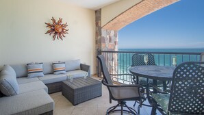 Ein Balkon mit einer Couch, Stühlen und einem Tisch.