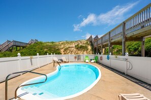 A swimming pool with a wooden deck, lounge chairs, and a view of a beach. - Absolute Searenity- Oceanfront, Pet-Friendly, Private Pool and Hot Tub (Nags Head)