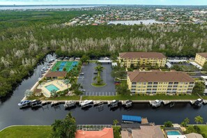 A waterfront hotel with a tennis court, boat dock, and parking lot. - Closest to the Pool! - Updated, Bright & Cheery - Condo Serenity Cove - Roelens Vacations (Cape Coral)