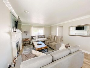Una sala de estar con chimenea, sofá, sillones y una mesa de centro.