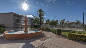 A fountain in a courtyard with a building in the background.