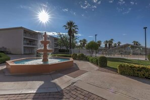 A fountain in a courtyard with a building in the background.