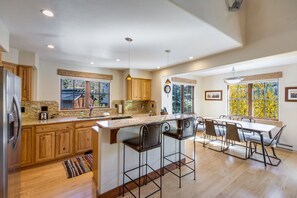 Una cocina amplia con armarios de madera, encimera de granito y una isla grande con taburetes de bar.