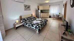 A compact hotel room with a bed, bedside table, lamp, kitchenette, and a small dining area. - Studio with terrace and air conditioning (Dramalj)