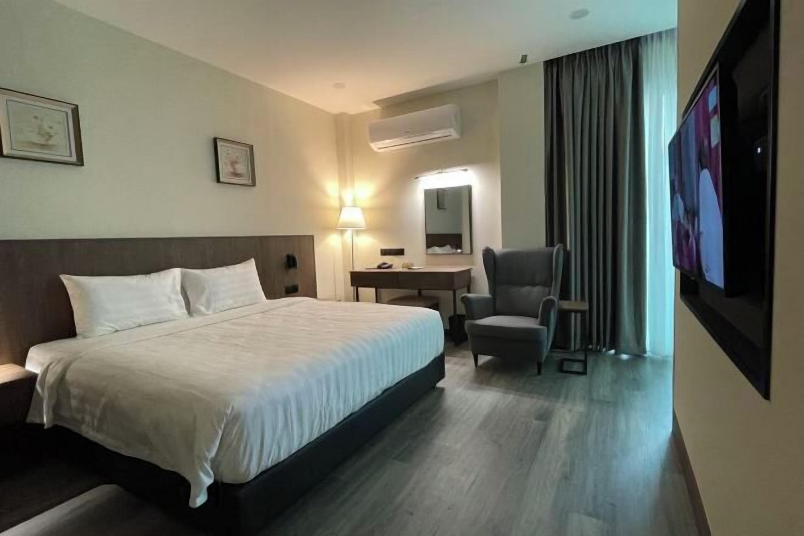 Una scrivania, postazione laptop, tende oscuranti, ferro/asse da stiro