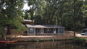 Eine Hütte am See mit einem Steg und einem Kajak.