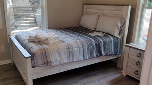 Ein Schlafzimmer mit einem Bett, einem Nachttisch und einem Fenster.