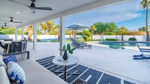 An outdoor patio area with a pool, lounge chairs, a table, and ceiling fans. - Multimillion $ ResortVilla+Waterslide+Pickleball+ (Scottsdale)