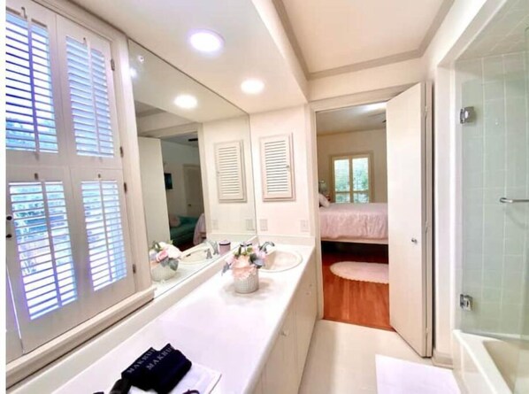 Bathroom features a bathtub, shower area, and seating area with a bench.