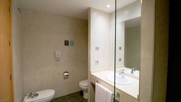 A modern bathroom with a toilet, sink, and mirror.
