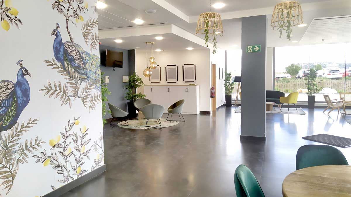A modern interior with a reception desk, seating area, and decorative wall art.