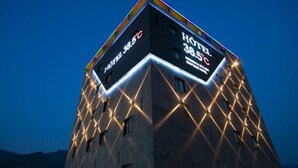 A hotel with a modern design, featuring a prominent sign displaying the name and temperature. - HOTEL 385 (Changwon)