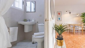 Une petite salle de bain comprenant un lavabo, des toilettes et une petite plante en pot.