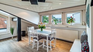 A modern kitchen with a dining area, large windows, and a view of the outdoors. - Holiday Apartment "Andrea" with A/C & Wi-Fi (Bühl)