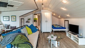 A modern apartment with a sofa, TV, and a dining area. - Holiday Apartment "Andrea" with A/C & Wi-Fi (Bühl)