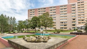 A multi-story building with a swimming pool, surrounded by trees and a landscaped area. - Holiday Apartment "Harzblick" with Mountain View, Balcony & Wi-Fi (Altenau)