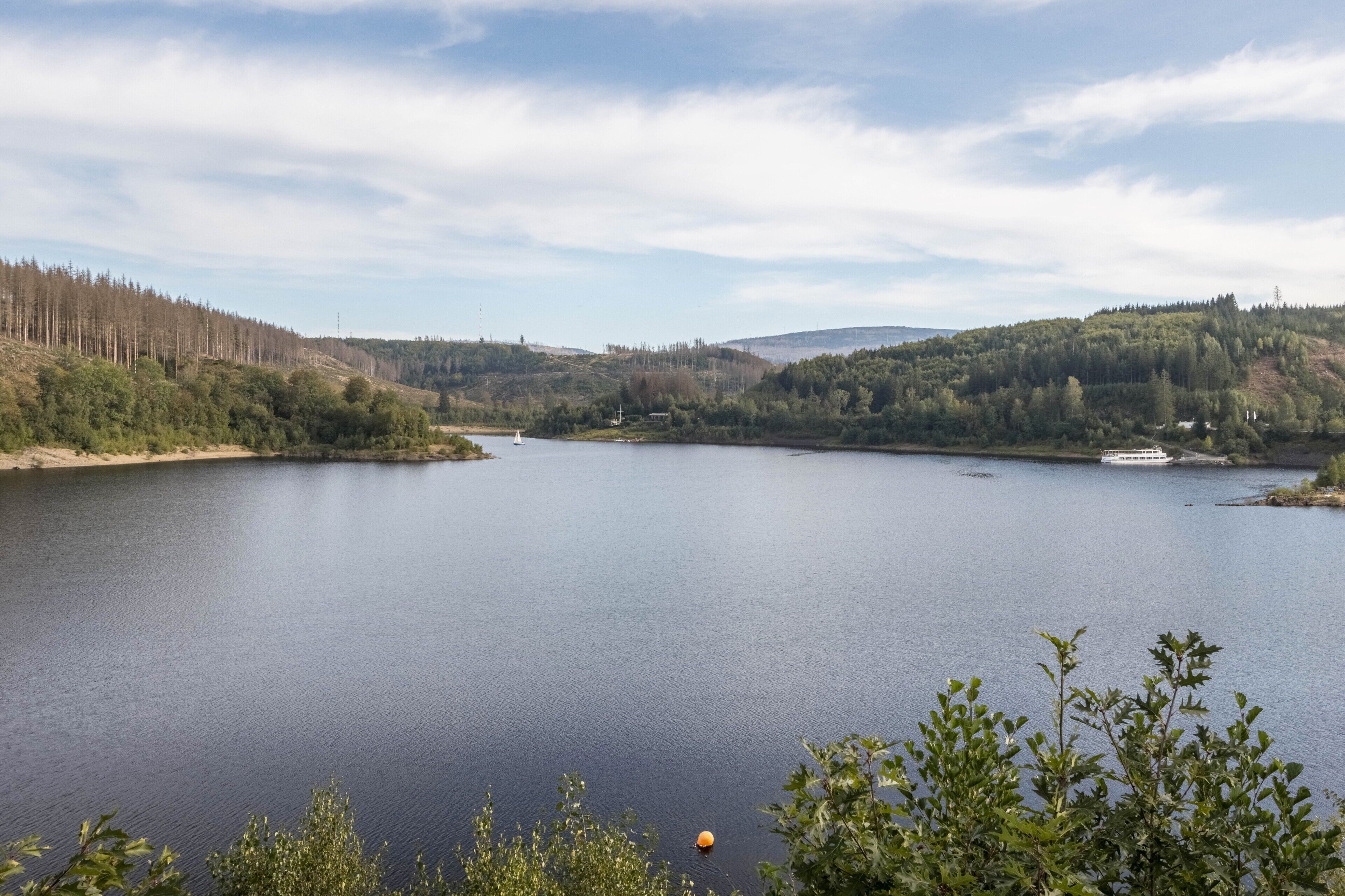 A calm lake surrounded by hills and trees.