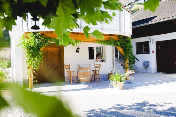 Un bâtiment doté d’une porte en bois, d’une fenêtre et d’un escalier menant à un garage.