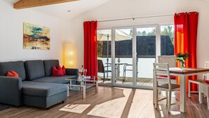 A modern living room with a sofa, coffee table, and dining area. - Holiday Home with Balcony, Terrace, Private Patio, Shared Garden and Wi-Fi (Salem)