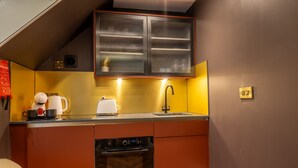 A compact kitchen with a built-in oven, a dishwasher, and a microwave.