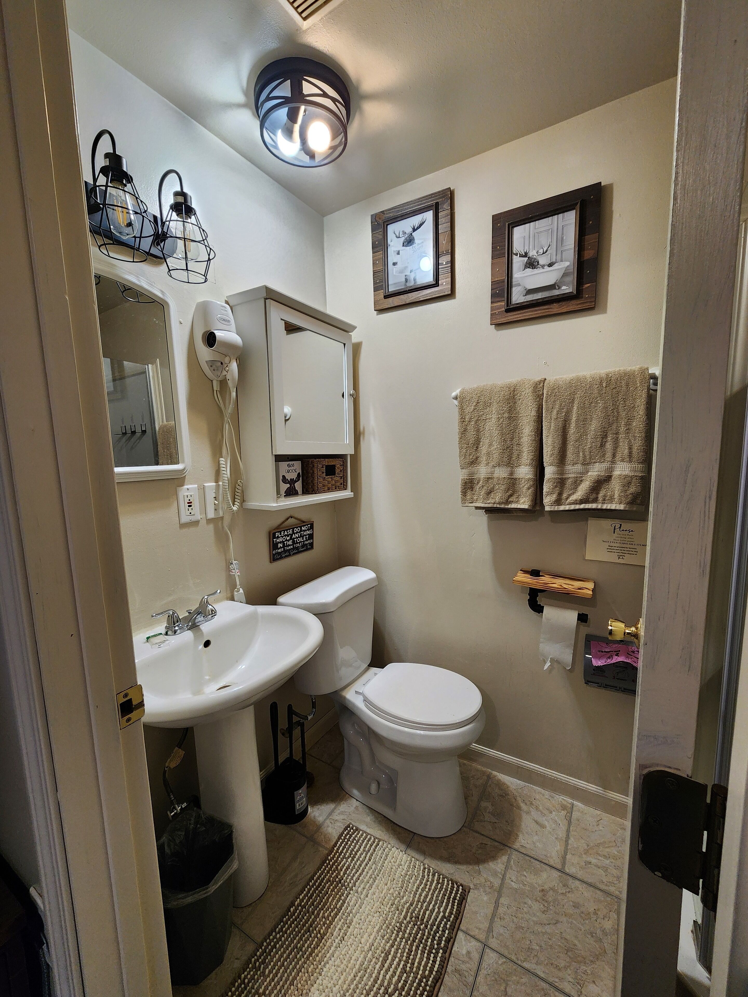 Une salle de bain équipée d’un lavabo, de toilettes et d’un porte-serviettes.