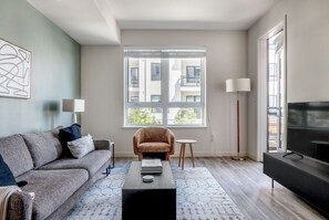 Relax in this stylish living room with a sofa, armchair, and flat-screen TV.