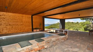 A stone-lined hot tub with a view of a mountainous landscape. - Villa Vela Baraka with private Pool, Dragove, Croatia (Dragove)