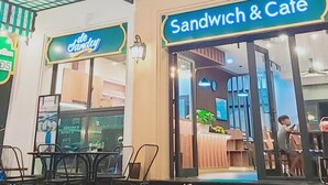 Un hotel con un letrero que dice "Hotel" y una cafetería de sándwiches con un letrero que dice "Sandwich & Cafe".