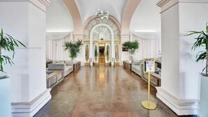 Eine prachtvolle Lobby mit hohen Decken, Rundbogenöffnungen und einem Kronleuchter.