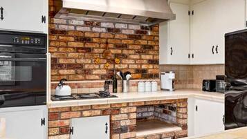 Eine Küche mit Backsteinrückwand, weißen Schränken und einem eingebauten Backofen.