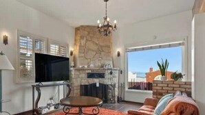 Una sala de estar con chimenea, televisor y zona de estar.