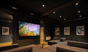 Un interior moderno con un cuadro abstracto grande, una zona de estar y obras de arte enmarcadas en las paredes.