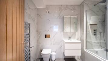 Bathtub, hair dryer, towels, shampoo
