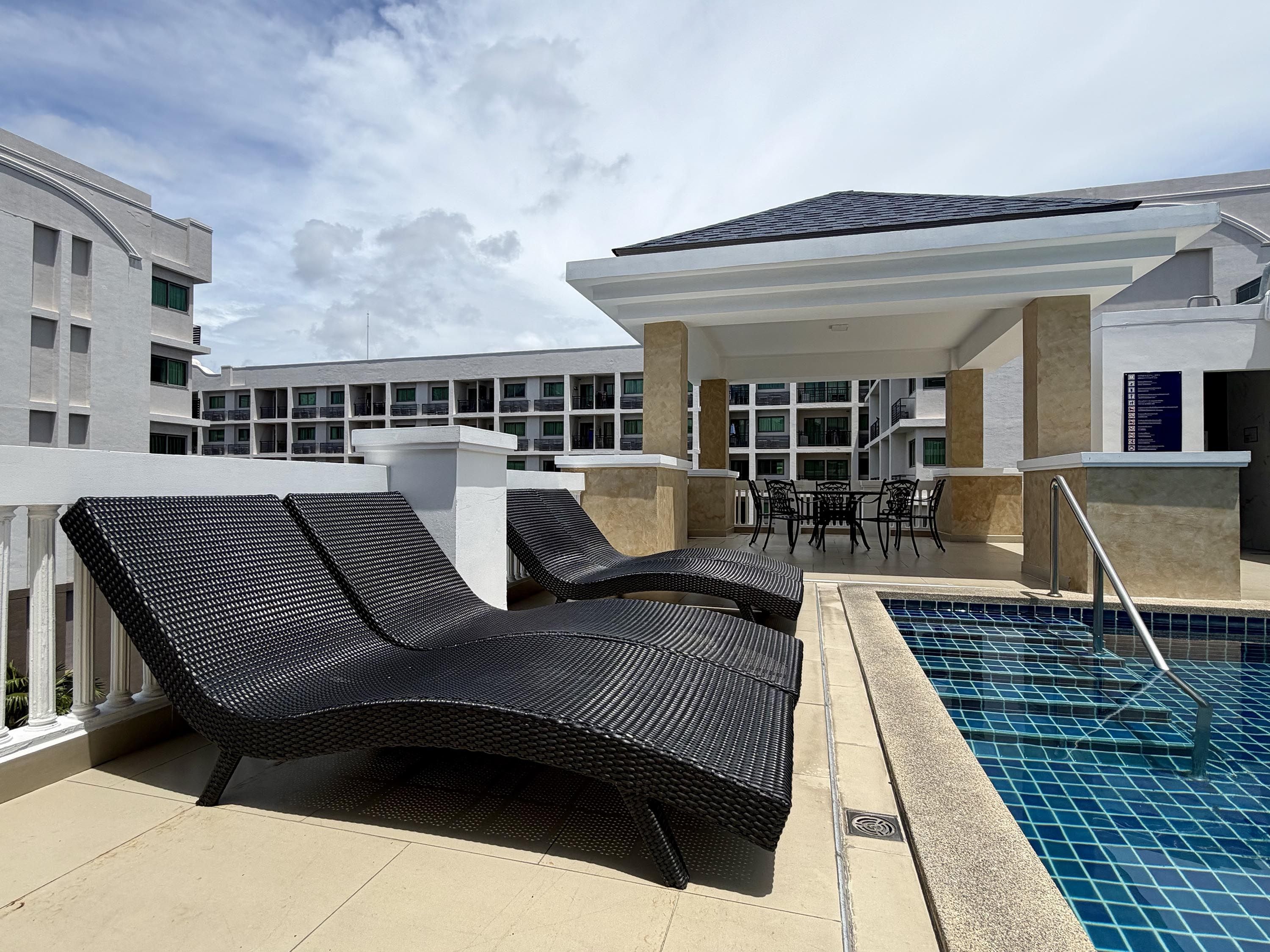A rooftop pool area with lounge chairs and a pool.