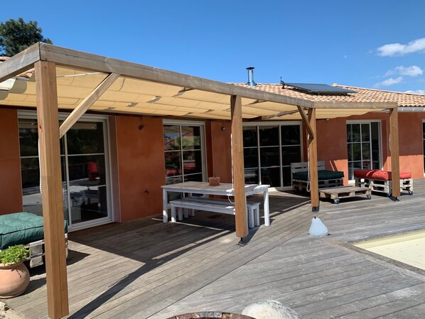 Enjoy al fresco dining on the covered patio with a table and benches.