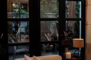 A room with large windows, a table with candles, and a lamp. - Hotel Boutique Cosmopolita Timisoara (Timisoara)