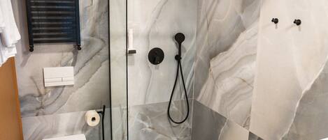 Un baño moderno con ducha de vidrio, inodoro y lavamanos.