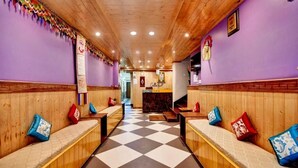 A restaurant with wooden booths, checkered flooring, and purple walls. - Parasol Inn Sikkim  (Gangtok)