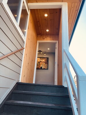 A wooden staircase leading to a room with a painting on the wall. - Green Lake 1st LineHome B with Whole House Central Air Conditioners (Seattle)