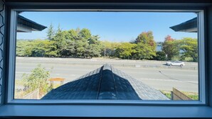 A view through a window of a parking lot with trees and a car in the distance. - Green Lake 1st LineHome B with Whole House Central Air Conditioners (Seattle)