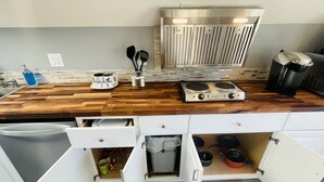 A modern kitchen with a wooden countertop, built-in stove, and white cabinetry with open shelves. - Green Lake 1st LineHome B with Whole House Central Air Conditioners (Seattle)