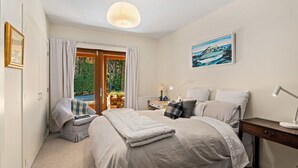 A bedroom with a bed, bedside table, lamp, and a painting on the wall.