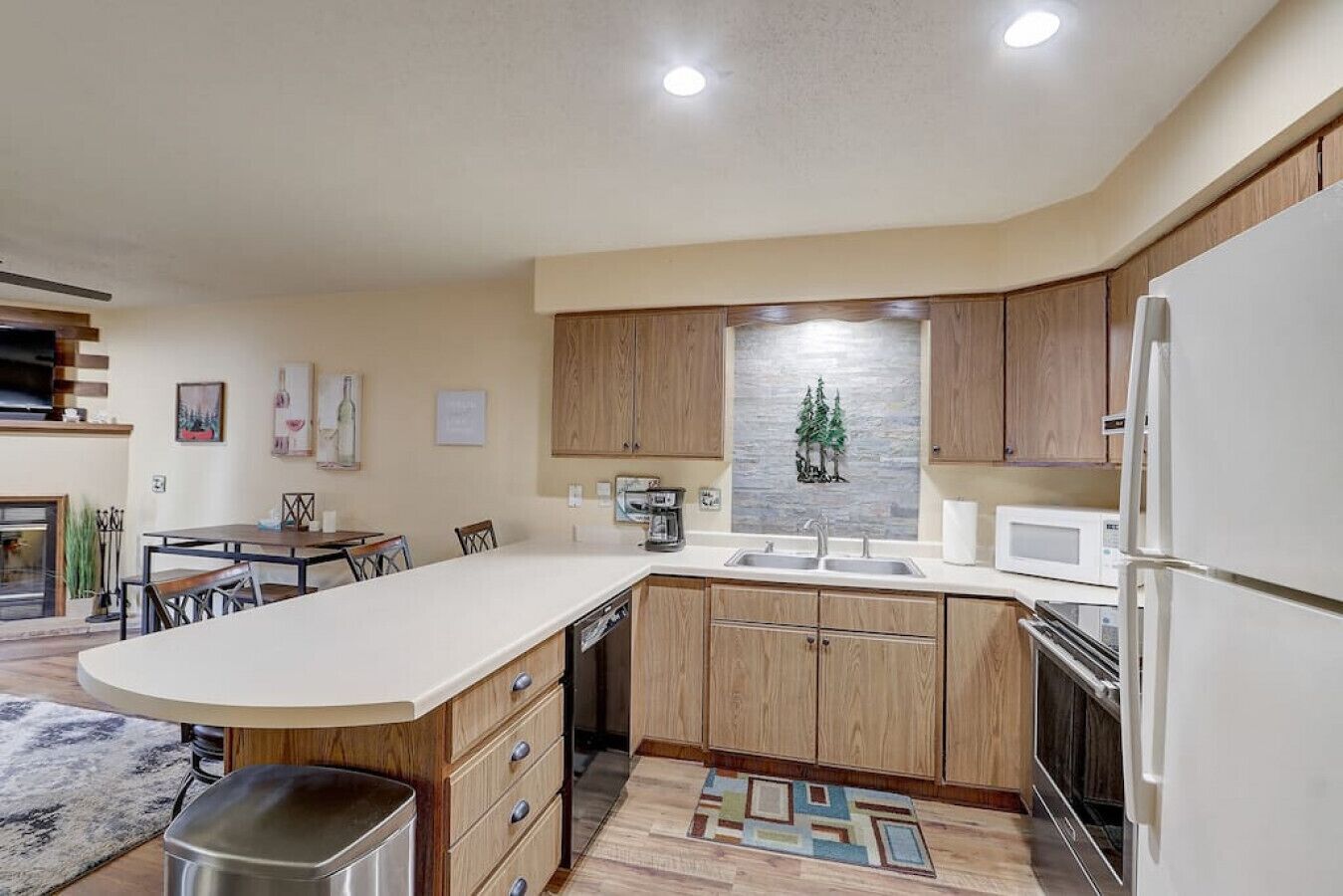 A modern kitchen with wooden cabinets, a built-in island, stainless steel appliances, and a decorative backsplash.